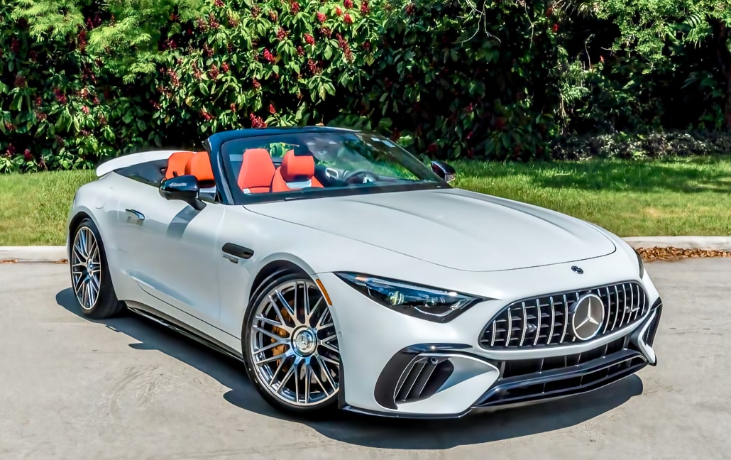 White Mercedes-Benz SL with the roof lowered and orange seats